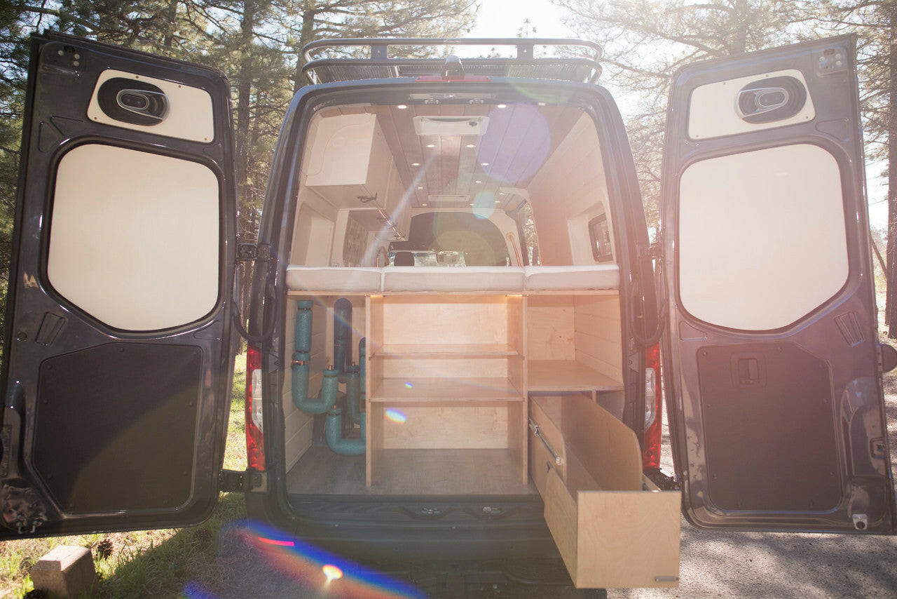 The fixed bed provides a garage space with customizable shelving and pull-out drawers.
